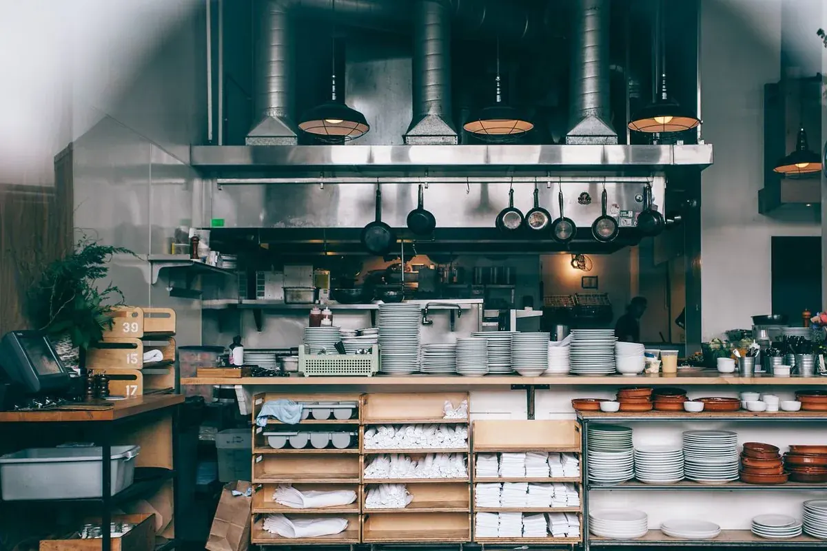 Commercial restaurant kitchen in Cape Coral, Florida with stainless steel exhaust hood and prep line