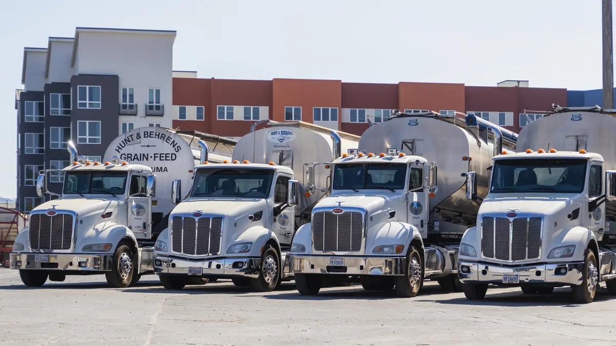 Vacuum tank trucks used for grease trap pumping parked in a service yard